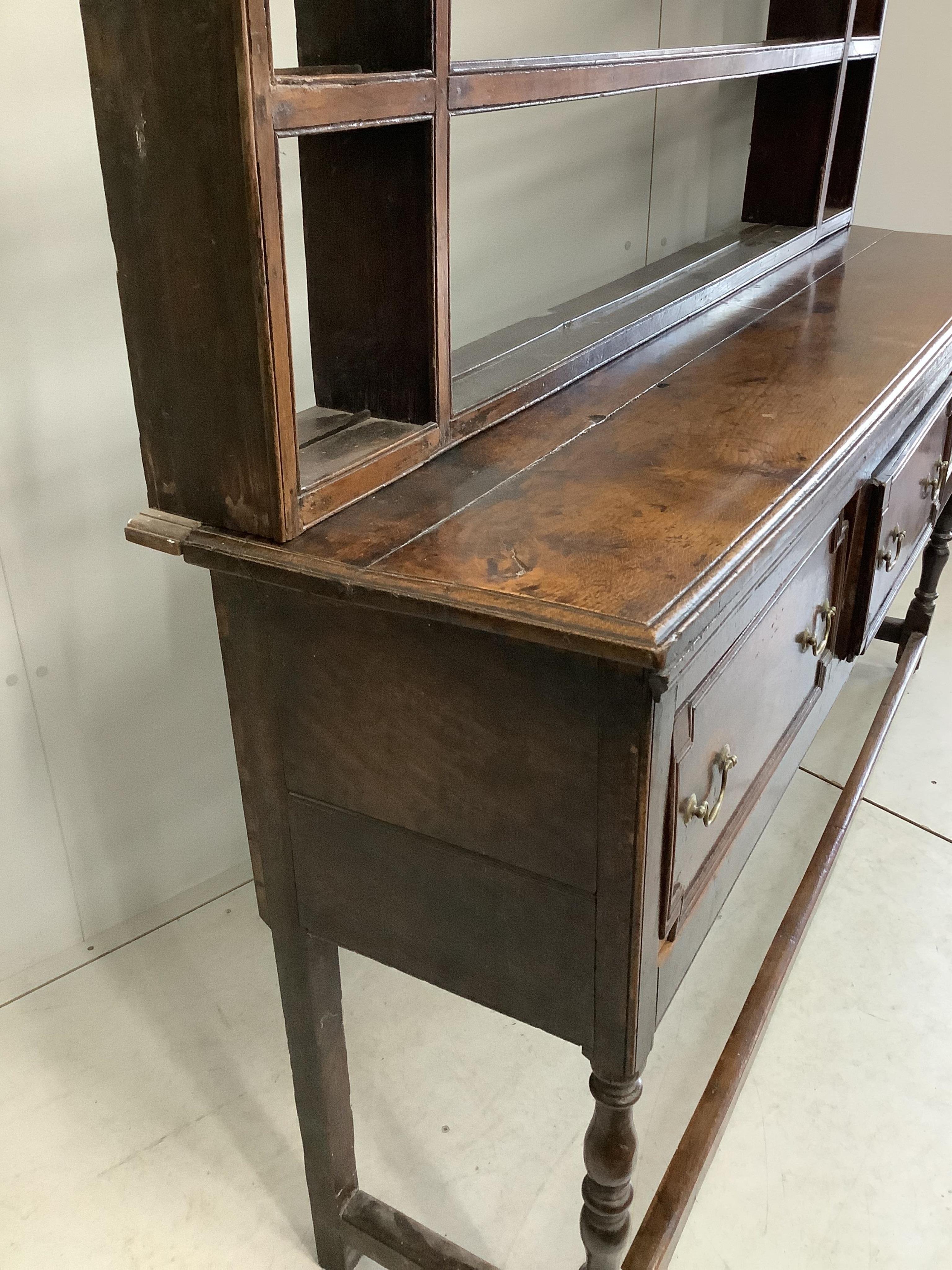 An 18th century oak dresser with open rack, width 176cm, depth 46cm, height 199cm. Condition - fair